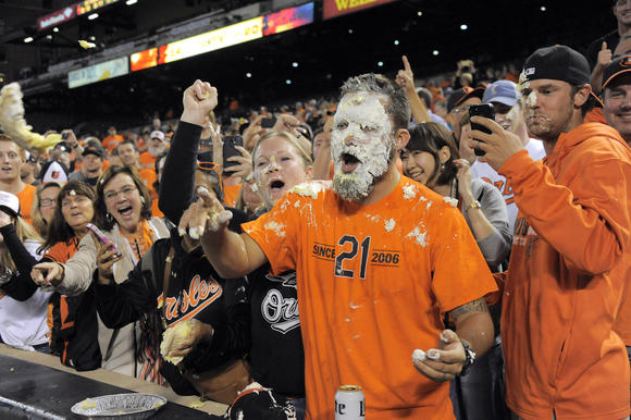 Fan Johnny Jackson of Elkridge reacts after being hit with a pie by Baltimore Orioles center fielder Adam Jones after defeating the Toronto Blue Jays Tuesday, Sep 16, 2014, as Baltimore wins its first AL East championship pennant at home since 1969. (Karl Merton Ferron, Baltimore Sun / September 16, 2014)